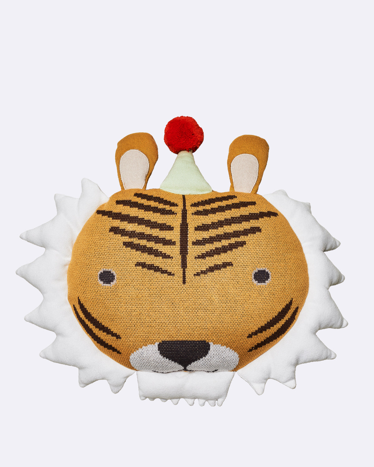 Kissen mit Tigerdesign, bunten Ohren und rotem Pompon auf einer cremefarbenen Fläche